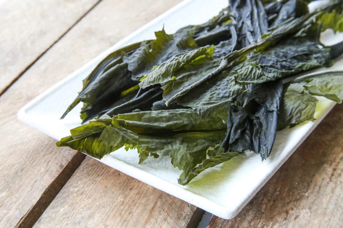 Dried seaweed on a white rectangular plate on a wooden surface