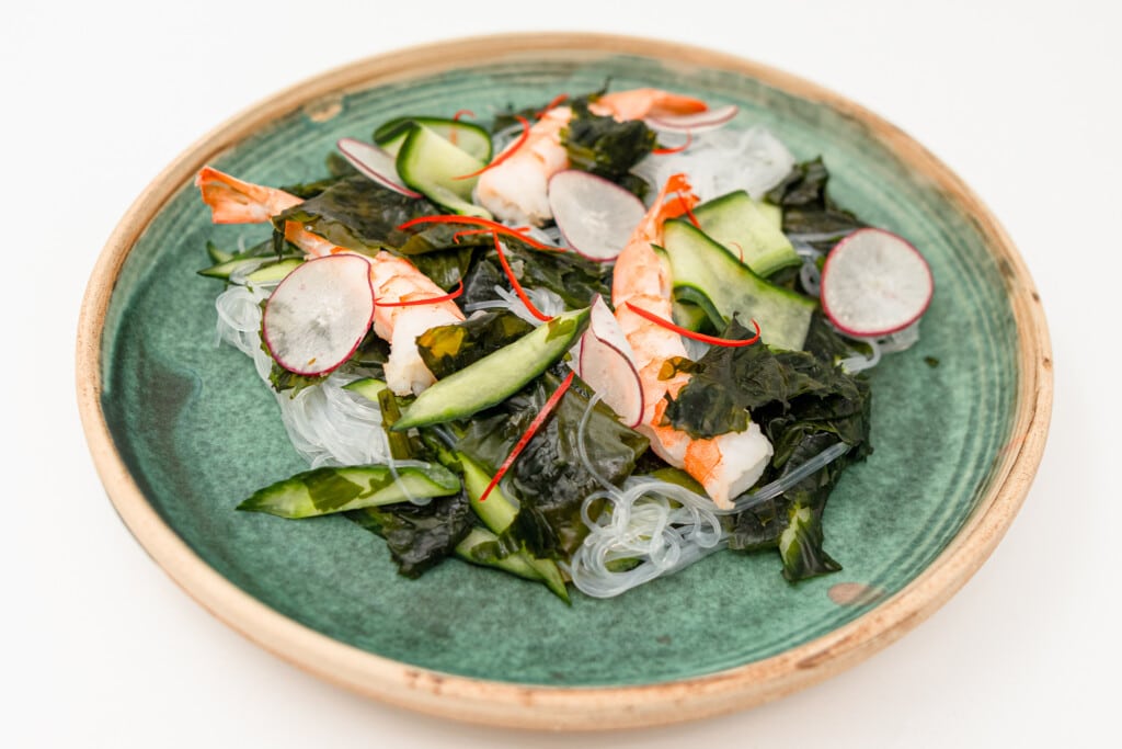 prawn noodle salad with winged kelp on a plate