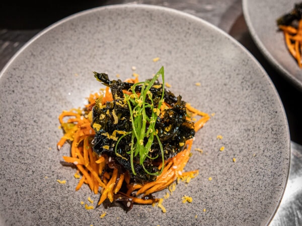 noodles on a plate with crispy seaweed topping