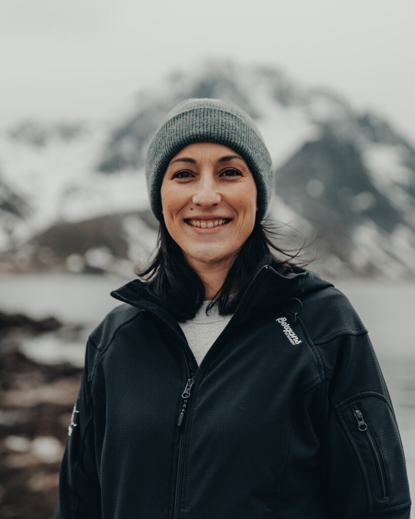woman in grey hat smiling with mountains